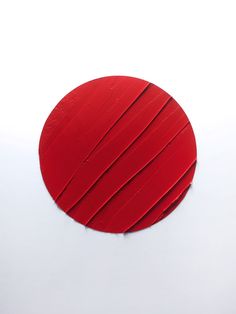 a round red object sitting on top of a white surface