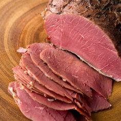 sliced meat sitting on top of a wooden cutting board