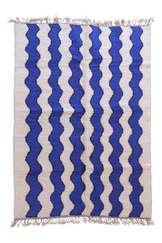 a blue and white striped rug with fringes on the bottom, in front of a white background