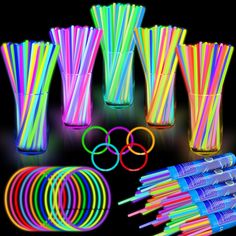 neon glow sticks, straws and cups are arranged on a black background with the colors of the rainbow