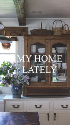 the words my home lately are displayed in front of a wooden cabinet with glass doors