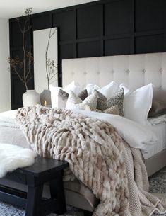 a bed with white pillows and blankets on top of it