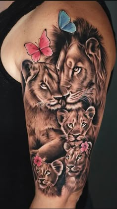 a woman's arm with tattoos on it and two lions in the middle, one is