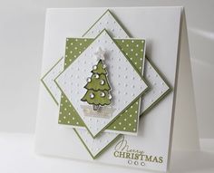 a christmas card with a green tree on the front, and white polka dot background