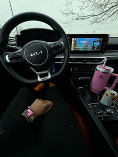 the interior of a car with steering wheel, dashboard and various items on display in front of it