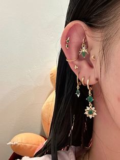 a close up of a person with ear piercings and an earring on their left side