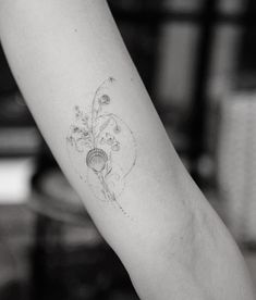 a woman's arm with a flower tattoo on the left side of her arm