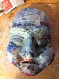 a face made out of newspaper sitting on top of a table