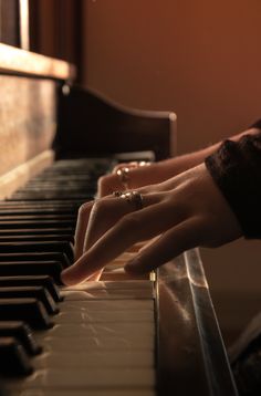 a person's hand on the keys of a piano