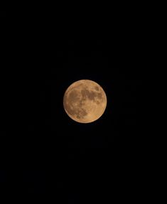 a full moon is seen in the dark sky