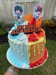 someone holding up a cake decorated to look like they are from my hero academy with stickers on it