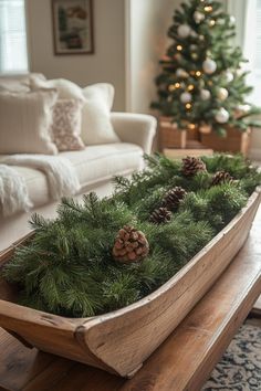 a wooden sled filled with pine cones and greenery next to a christmas tree