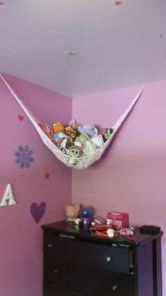 a hammock hanging from the ceiling in a child's room with pink walls