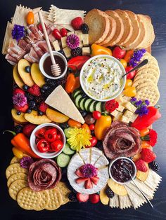 a platter filled with cheese, crackers and fruit