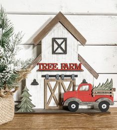 a red truck is parked in front of a white barn with a tree farm sign