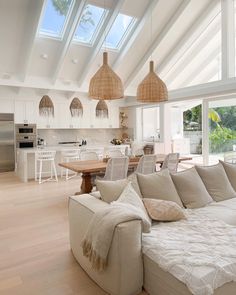 a large living room filled with furniture and lots of windows on top of the ceiling