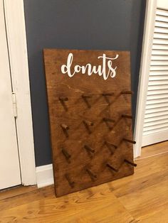 a wooden sign that says donuts on it in front of a door with the word donuts painted on it