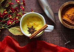 a cup with cinnamon and anise on it next to two bowls filled with spices