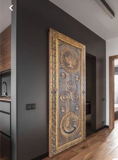 a large metal door in the middle of a room with wood floors and walls,