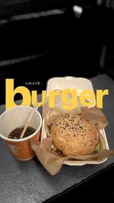 a burger and coffee sit on a table with the words burger written in large yellow letters