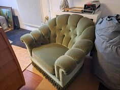 a green chair sitting on top of a hard wood floor