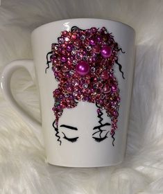 a white coffee cup decorated with pink and purple beads