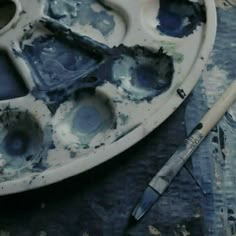 an artist's palette with paint and brushes on it