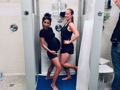 two women are standing in the shower with their feet on the ground and one woman is smiling