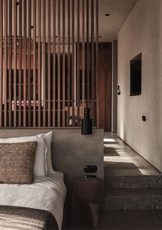 a bed sitting under a wooden slatted wall