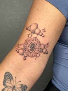 a woman's arm with a butterfly on it and some balls in the middle