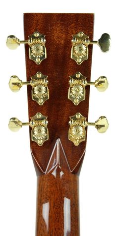 an acoustic guitar neck with gold hardware