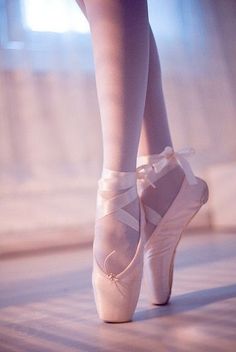 a close up of a person's feet wearing ballet shoes