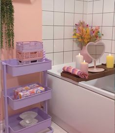 a bathroom with pink walls and purple shelves on the bathtub next to a candle