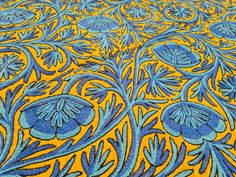 an intricately designed table cloth with blue and yellow colors