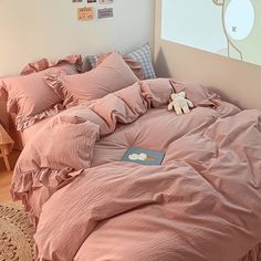 a bed with pink sheets and pillows in a room