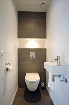 a white toilet sitting in a bathroom next to a wall mounted faucet and sink