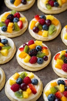 small cookies with fruit on them sitting on a baking sheet, ready to be baked