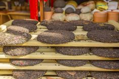 there are many different types of donuts on the shelves in front of each other