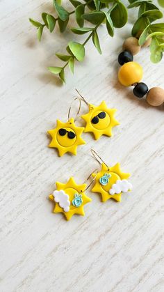 Brighten up your day with these charming polymer clay sun theme hoop earrings. Whether you're heading to a beach party or simply soaking up the rays on a sunny day, these hoops are the perfect accessory. You may choose from a sun adorned with flowers or stylish sunglasses.  The lightweight design makes them comfortable to wear all day long, and the 18K gold plated brass ear wires make them safe for sensitive ears. The dimensions of the hoops are 1.33'' x 1.18" x 0.03" (33.69mm x 30mm x 0.07mm) Clay Beach Earrings, Summer Gift Earrings In Polymer Clay, Polymer Clay Sun, Sunset Clay Earrings, Moon And Sun Earrings Clay, Sun Polymer Clay Earrings, Unique Yellow Polymer Clay Jewelry, Weather Theme, Unique Products Design