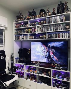 a gaming room with a large television and shelves full of video game memorabilia on the wall