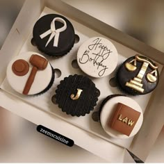 a box filled with cupcakes decorated like law and auction related items on top of each other