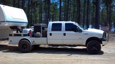 a white truck with a camper attached to the back