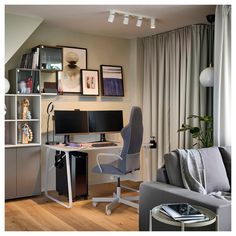 a living room with a couch, computer desk and bookshelf on the wall