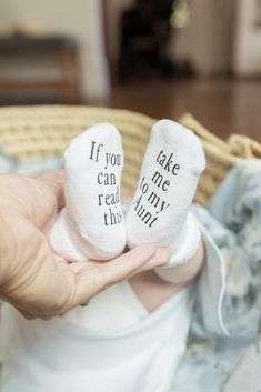 someone is holding two baby socks that say if you can read this