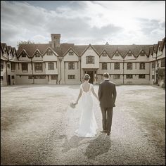 a bride and groom standing in front of a large building