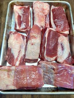 raw meat sitting on top of a metal pan