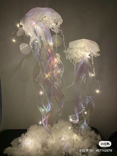 two jellyfishs are floating in the air with lights on their head and body