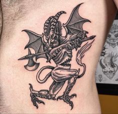 a man with a tattoo on his stomach holding a knife and an evil demon in it