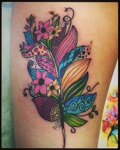 a colorful flower tattoo on the thigh