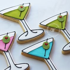 decorated cookies in the shape of martinis with green and pink decorations on them are arranged next to each other